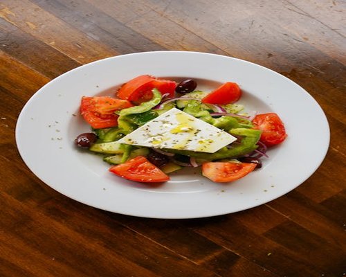 A fresh Greek salad with olive oil, tomatoes, and olives